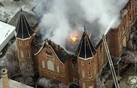 Aerial drone-style shot of the Provo Tabernacle roof on fire with thick smoke billowing from the historic brick structure.