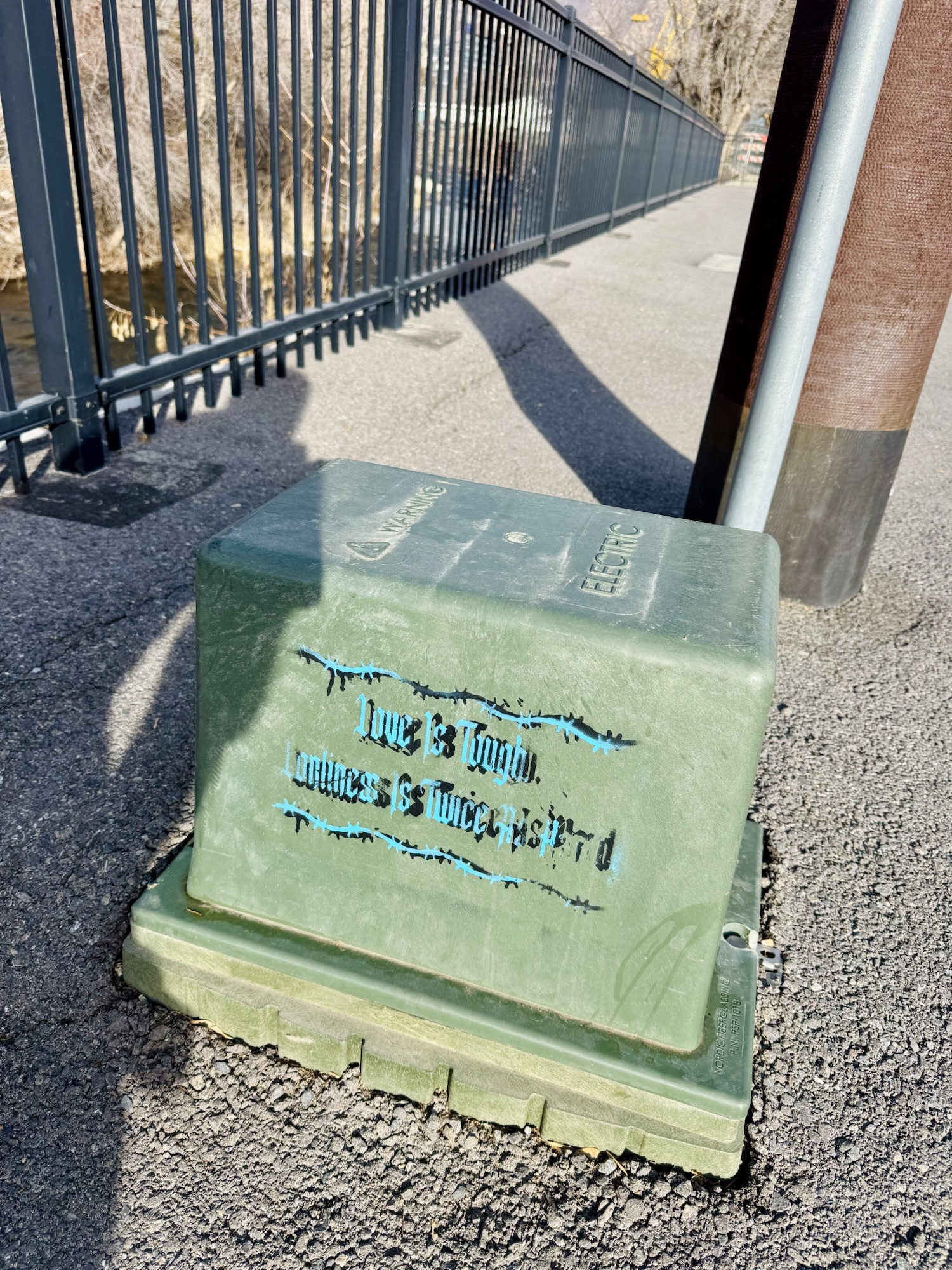 A quote about love and loneliness on a trail power box, documented by Jared Harding Wilson.