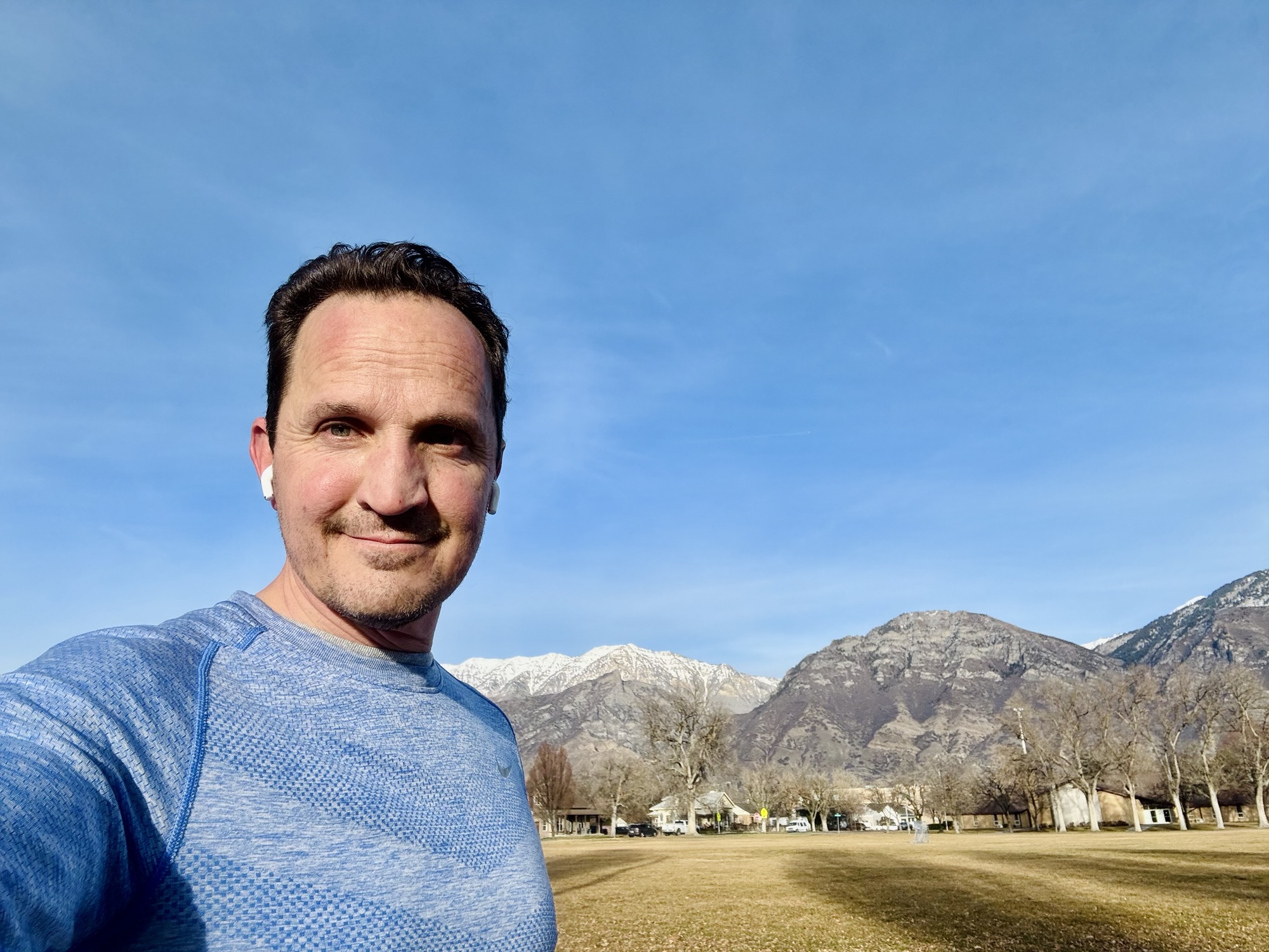 Jared Harding Wilson taking a selfie with the vast Utah mountains in the background after an eco-friendly trail run.