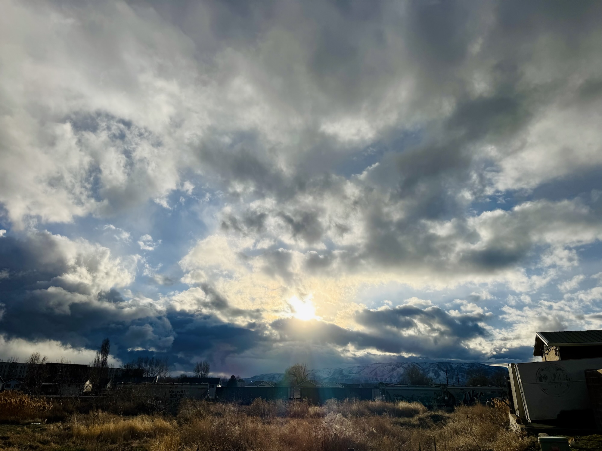 A horizontal sunset photograph of an open field and train cars by Jared Harding Wilson.