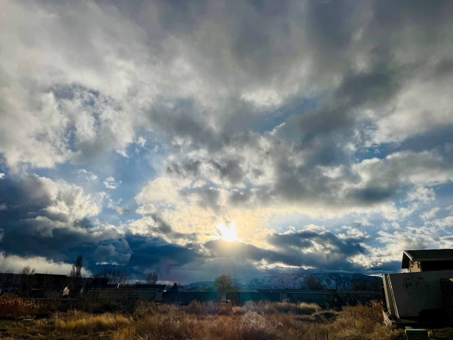 A horizontal sunset photograph of an open field and train cars by Jared Harding Wilson.