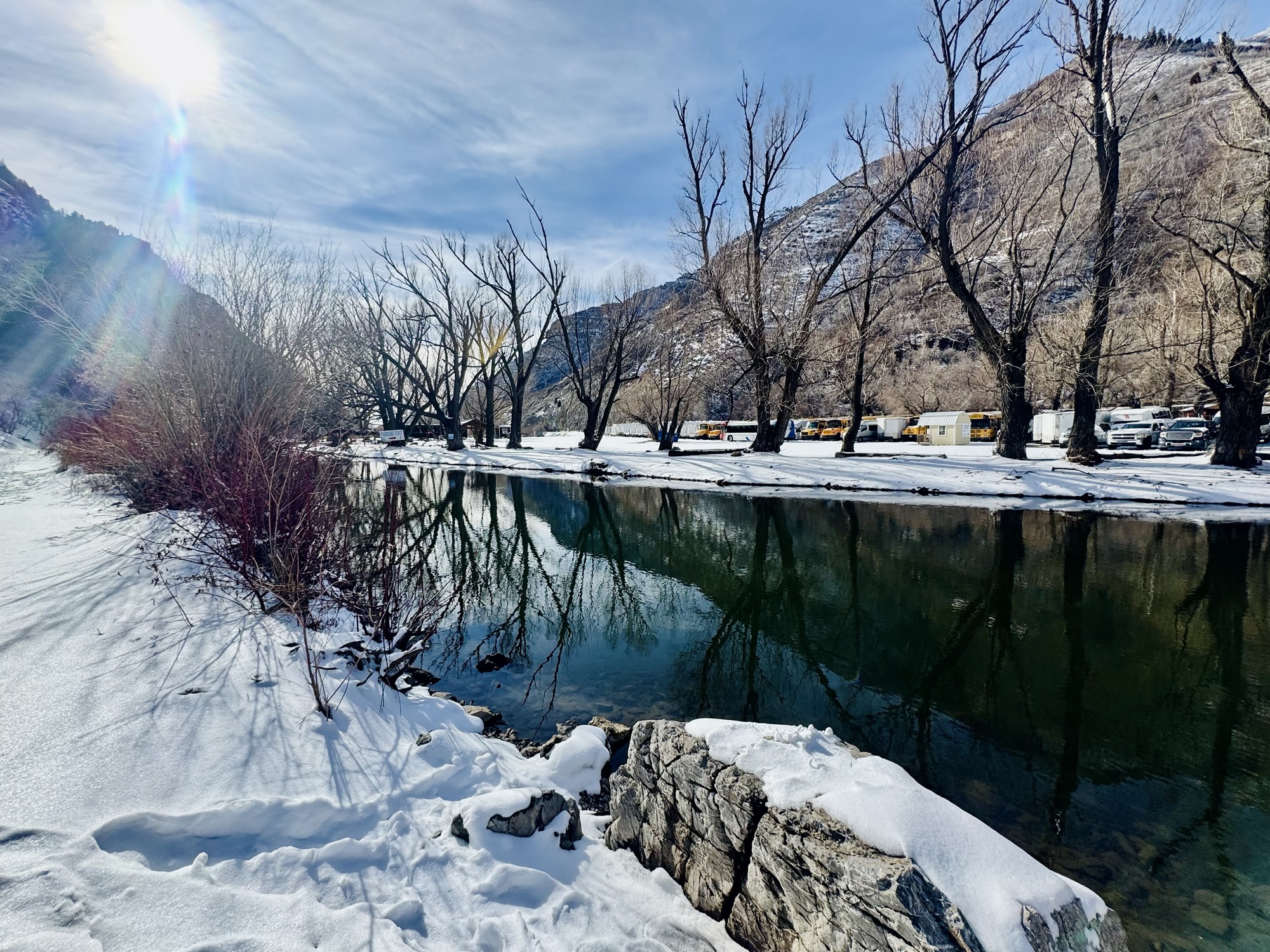 A wide, calm section of the Provo River in the canyon during winter, photographed by Jared Harding Wilson.