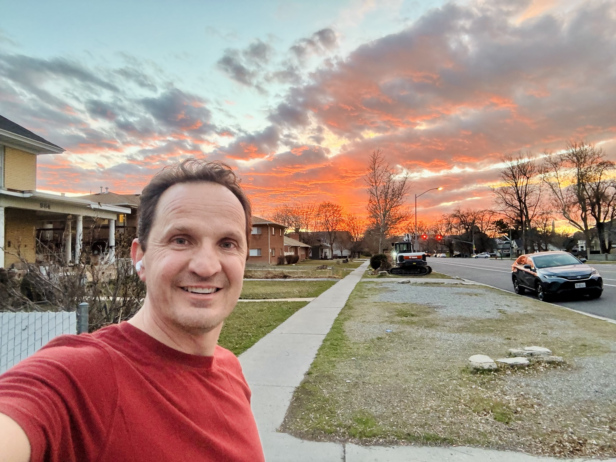 A selfie of Jared Harding Wilson smiling in front of a brilliant orange and pink Utah sunset.