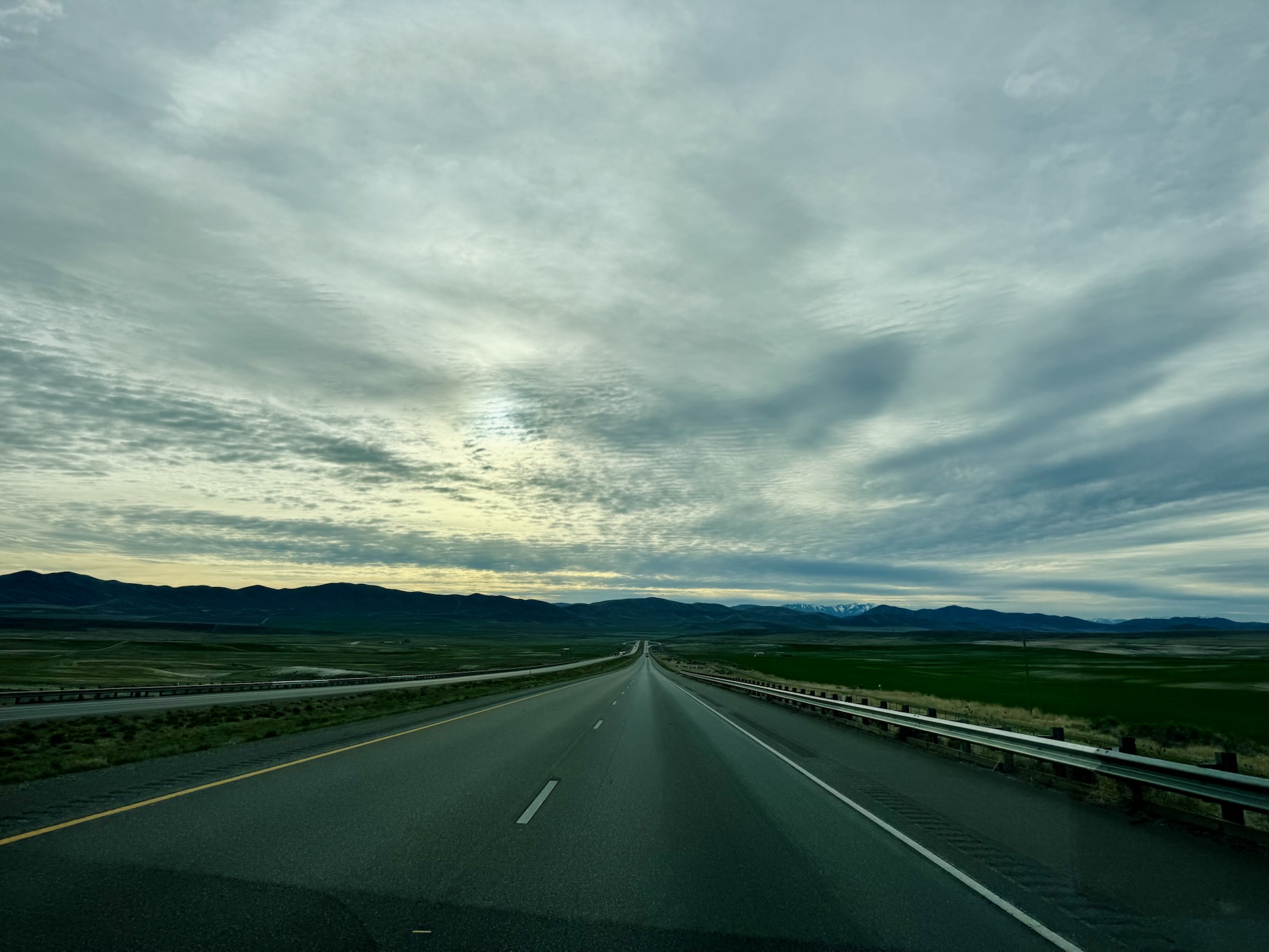 An open road under blue-gray overcast skies during the drive home to Utah, photographed by Jared Harding Wilson.