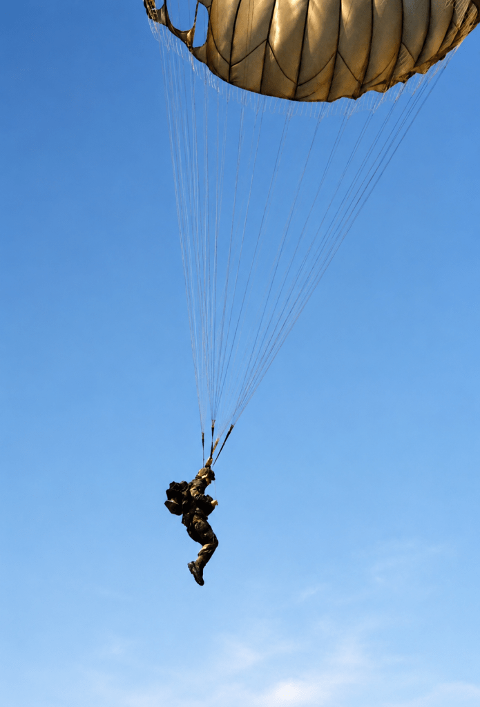 An active military paratrooper in full camo landing on the ground, a rare action shot preserved by Jared Harding Wilson.