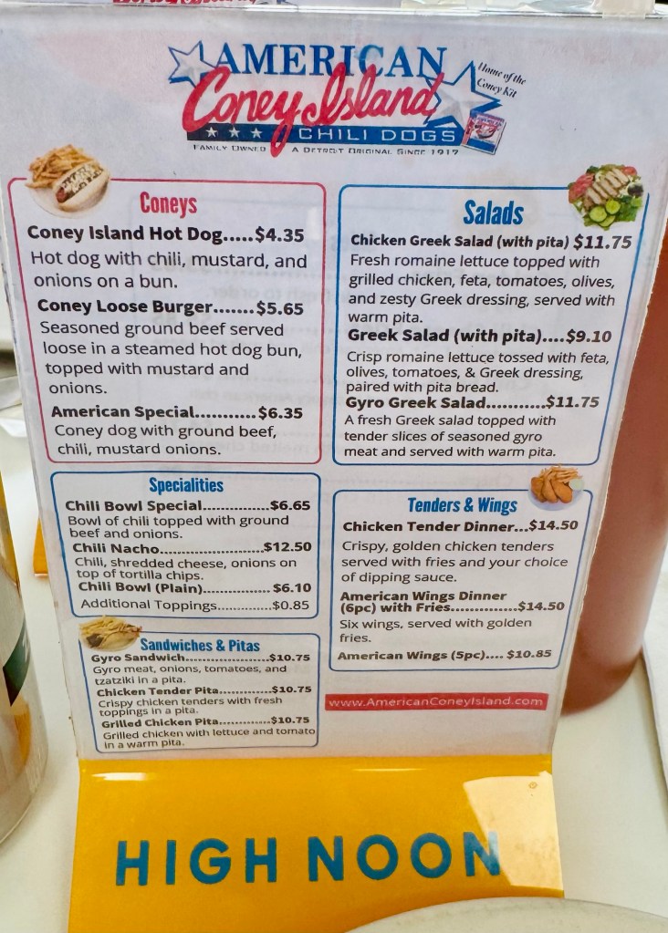 A close-up of the American Coney Island menu featuring classic hot dogs and regional Vernors ginger ale, captured by travel blogger Jared Harding Wilson.